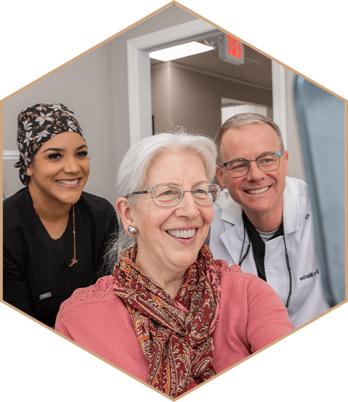 Dr. Brian Marino and a team member smiling with a patient at Montville Center for Dentistry