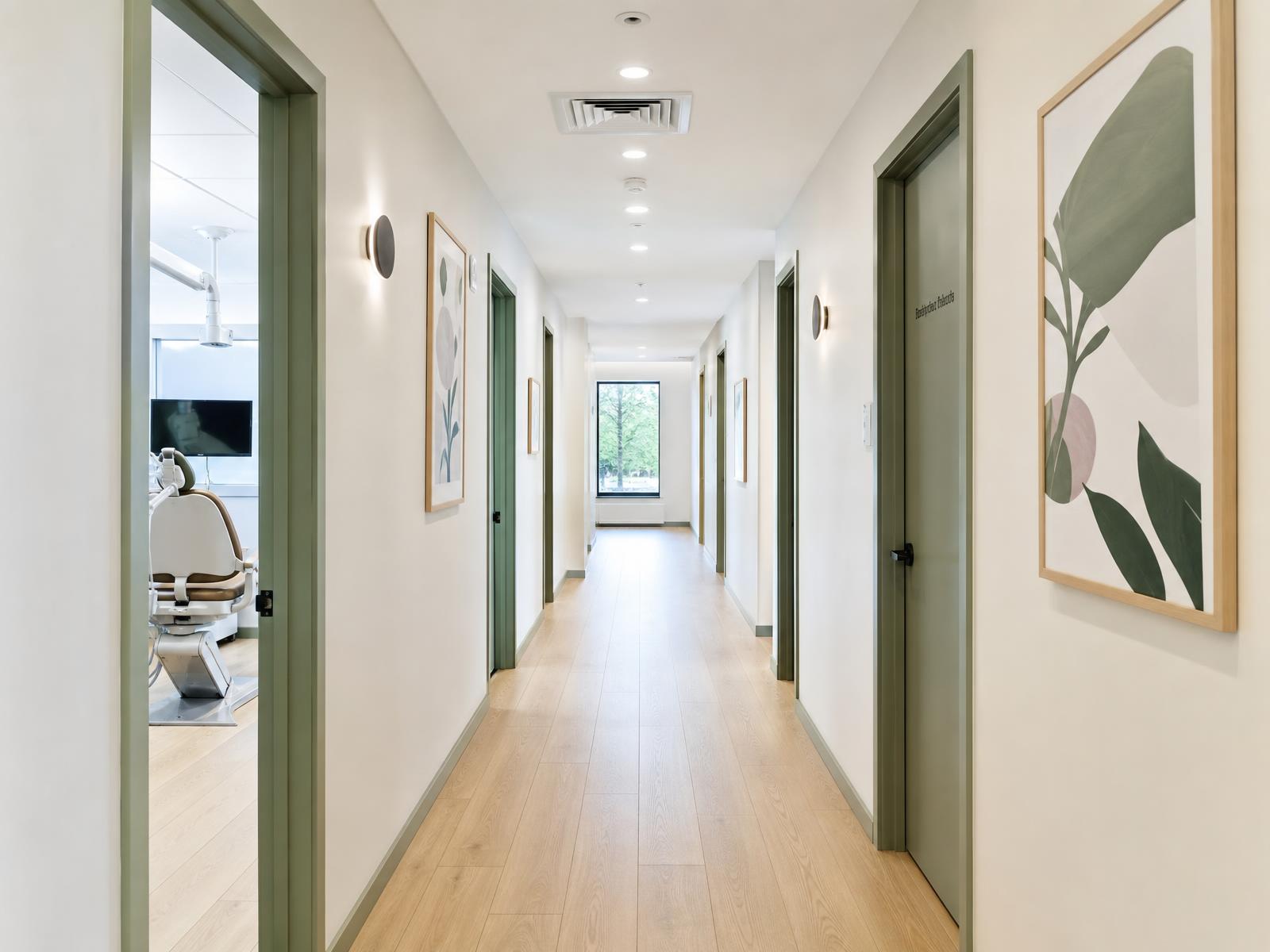 Calm hallway with light oak floors leading to treatment rooms