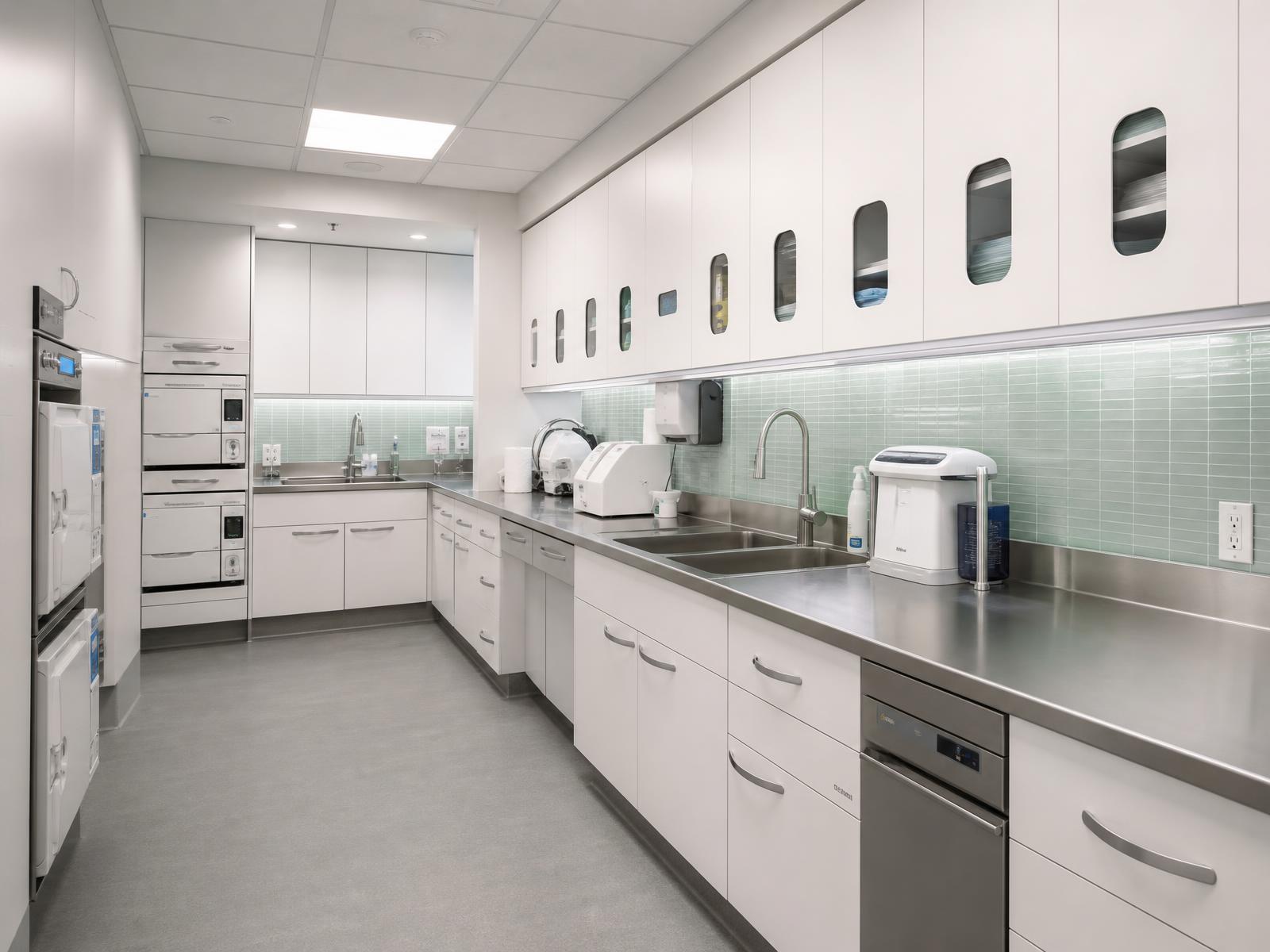 Clean sterilization suite with stainless steel counters and white cabinetry